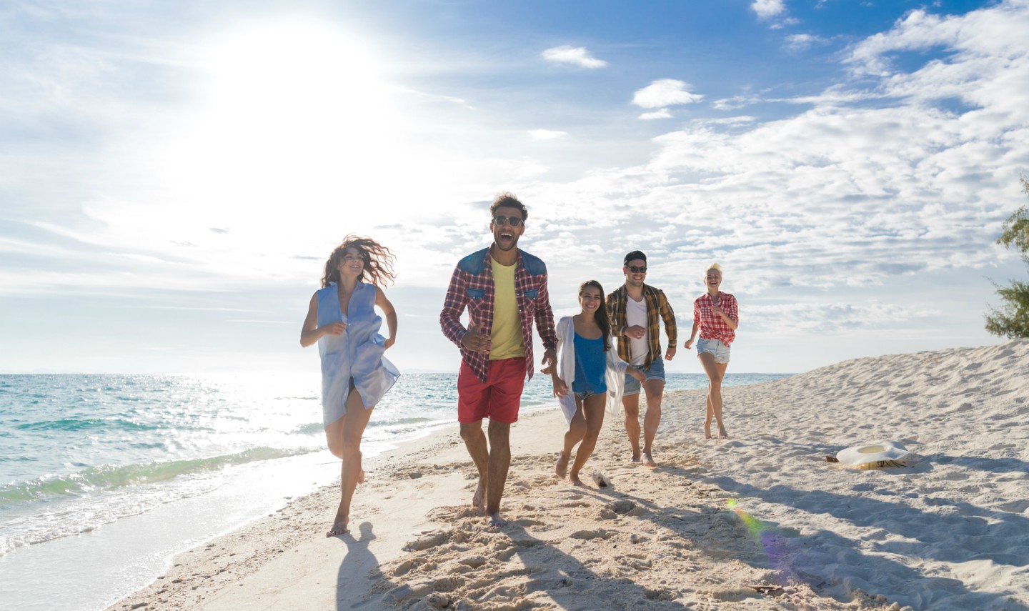jongeren-groep-op-strand-zomervakantie-gelukkig-lachende-vrienden-wandelen-zee-oceaan-vakantie-reizen